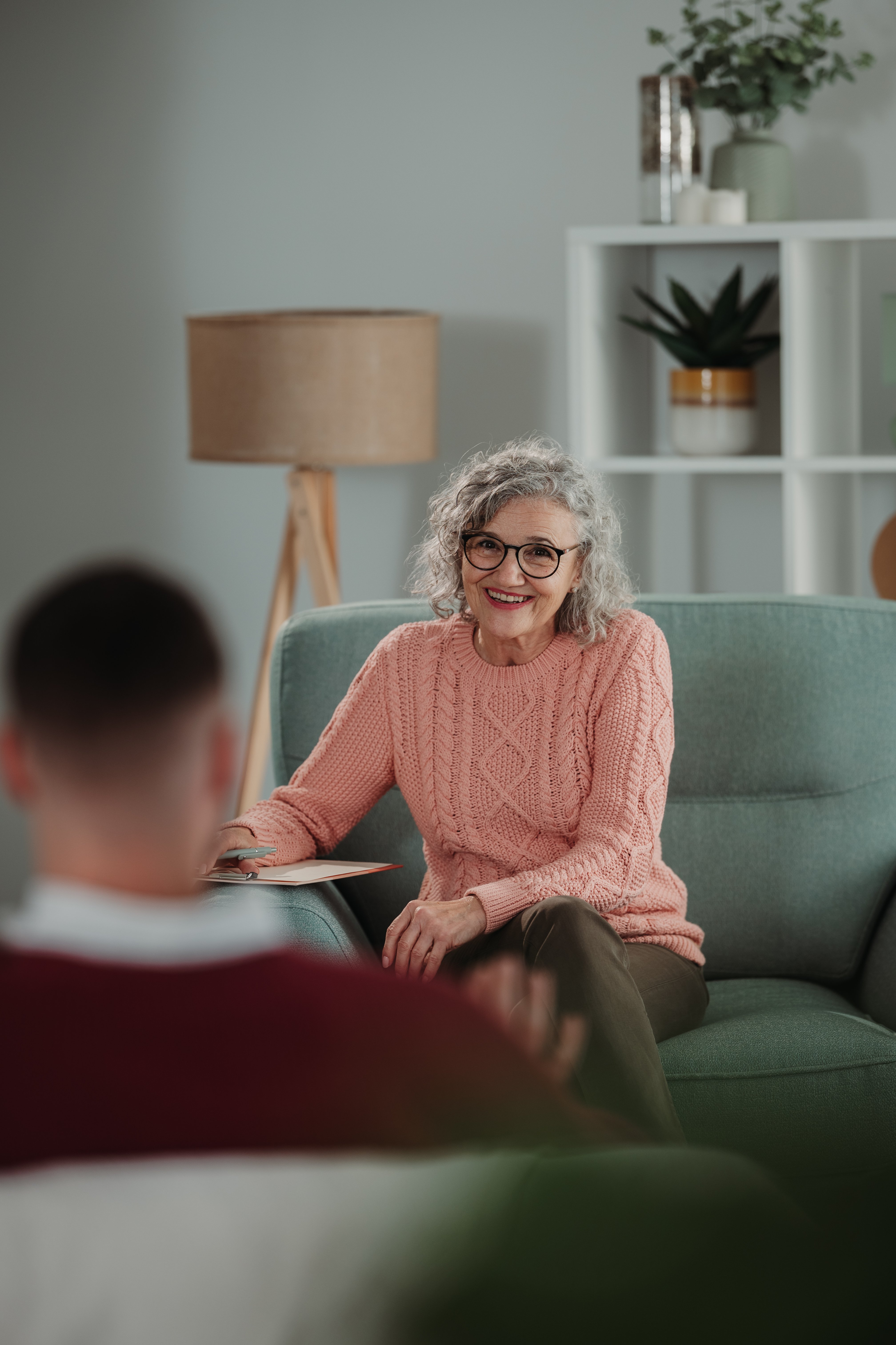 Smiling woman conducting a counseling session with a male patient, focusing on mental health and support